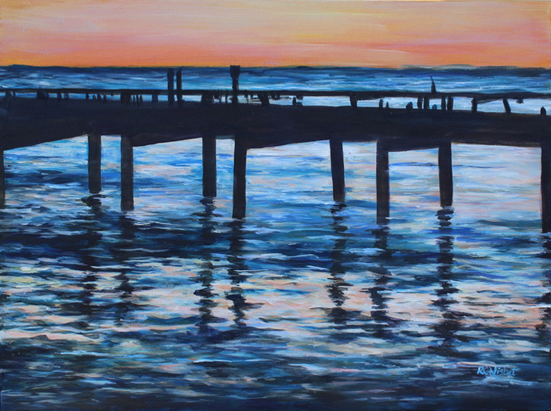 Pier over water at sunset
